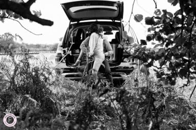 Couple enjoy moment of car sex outside in the back of their open car.