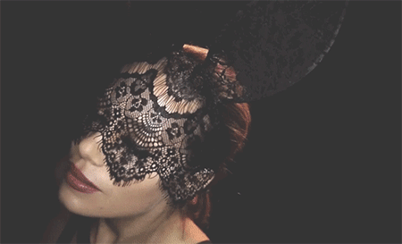 Woman in black lace headgear has a leather bondage collar attached during some kink and soft BDSM